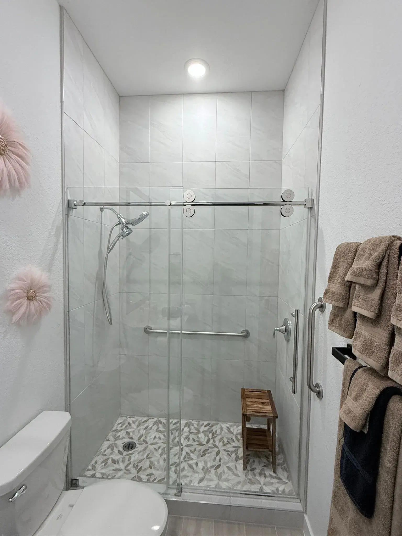 Frameless glass walk-in shower with mosaic tile floor, remodeled by YG Reno
